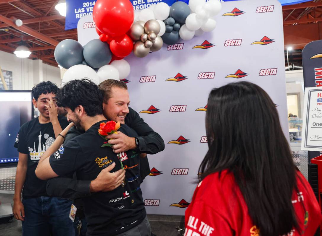 Alex Bechtler, a manufacturing teacher, hugs a student at Southeast Career Technical Academy in ...