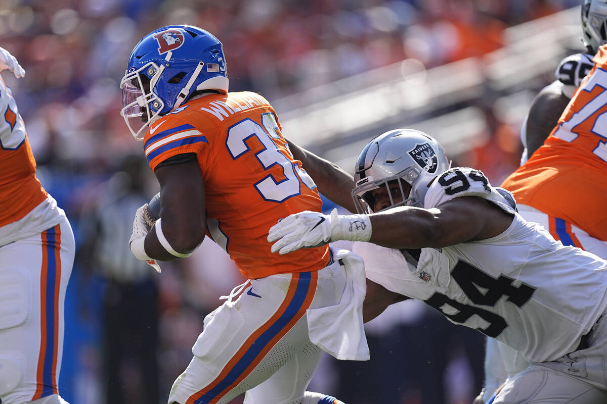 Denver Broncos running back Javonte Williams (33) is tackled by Las Vegas Raiders defensive ta ...