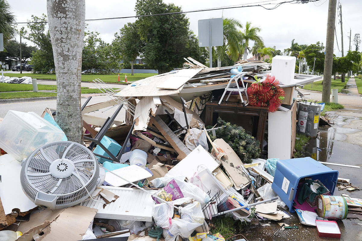 Montones de escombros se alinean en las aceras del barrio histórico de Punta Gorda dañado por ...