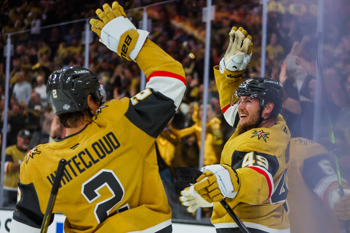 Golden Knights defenseman Zach Whitecloud (2) celebrates with Golden Knights center Ivan Barbas ...