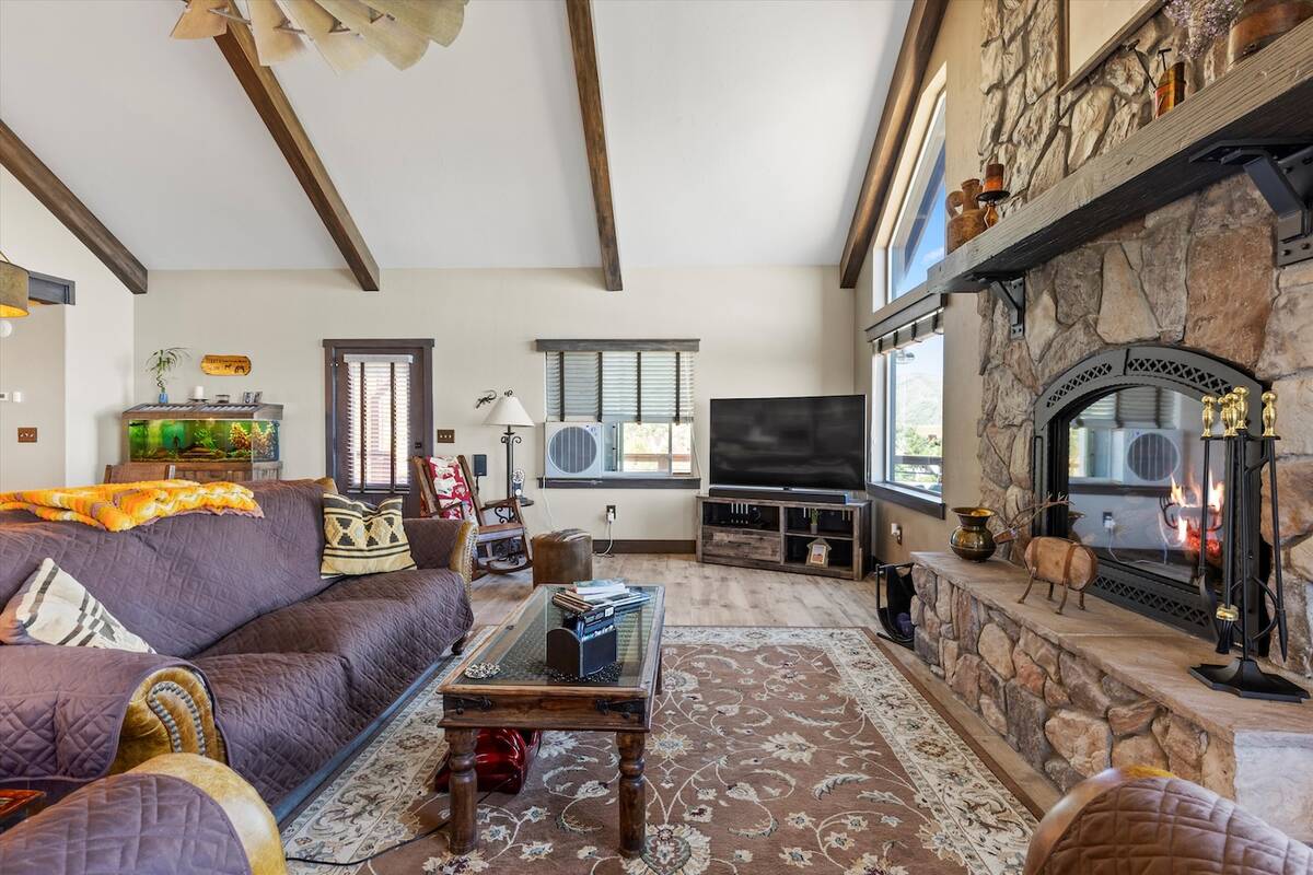 The interior boasts ceramic tile flooring, a vaulted wood-beamed ceiling and natural, rustic ma ...