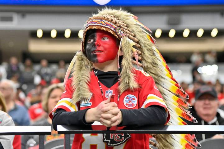 A young Kansas City Chiefs fan, dressed with a headdress and face paint, looks on during an NFL ...