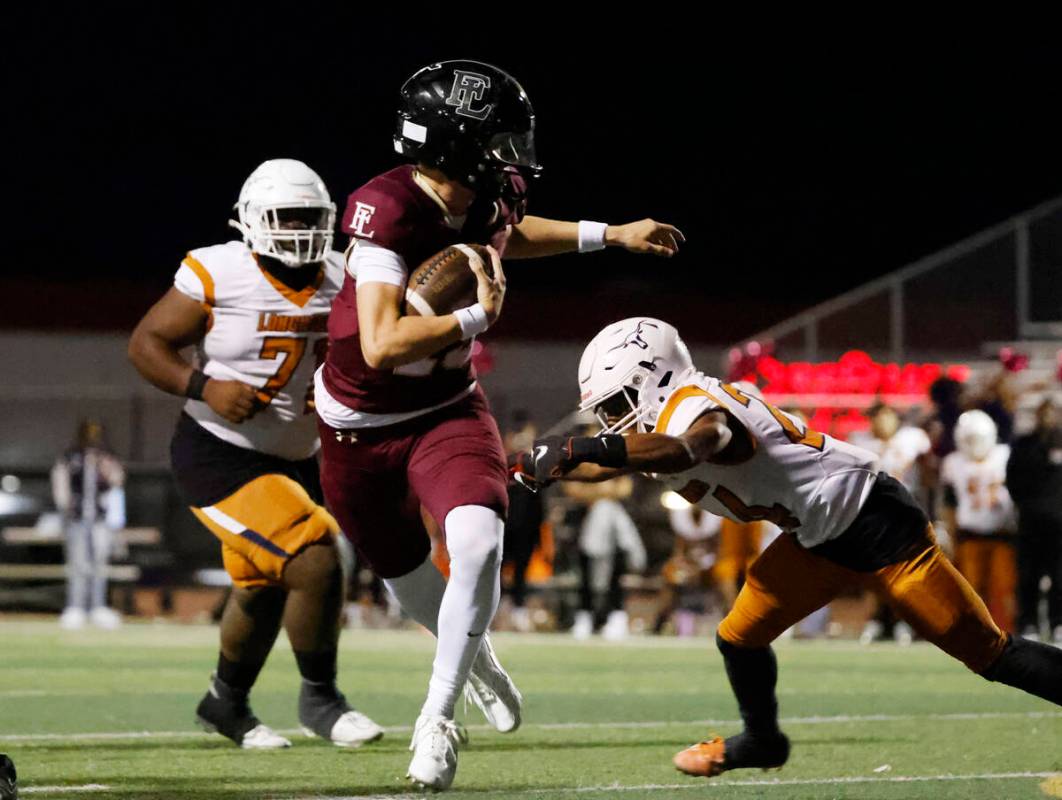 Faith Lutheran's quarterback Alexander Rogers (15) avoids a tackle from Legacy High's linebacke ...