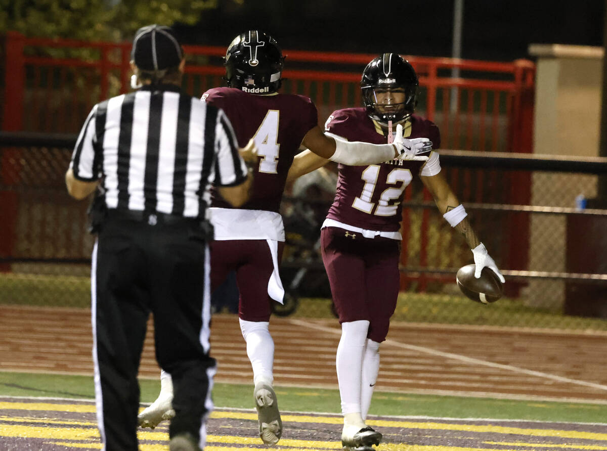 Faith Lutheran's wide receiver Aipa Kuloloia (12) celebrates his touchdown with Rouselle Shepar ...