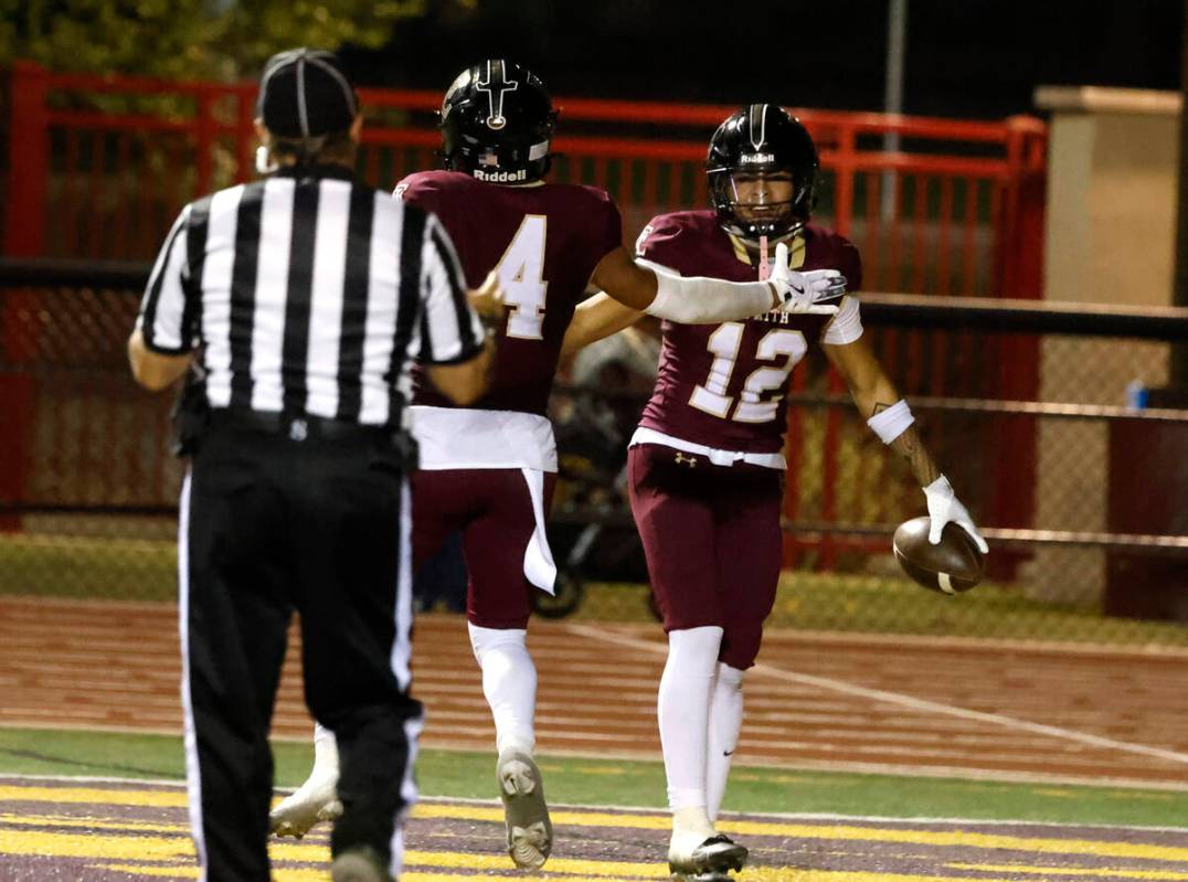 Faith Lutheran's wide receiver Aipa Kuloloia (12) celebrates his touchdown with Rouselle Shepar ...