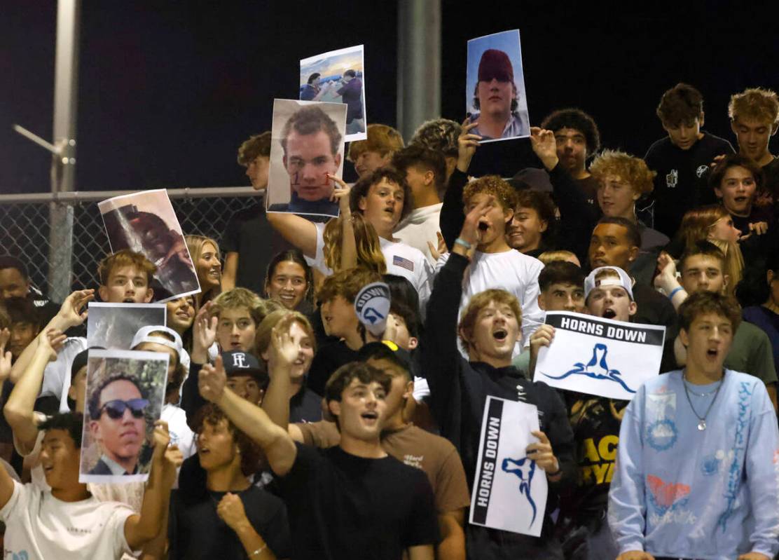 Faith Lutheran High's fans display players photographs as they cheer for their team during the ...