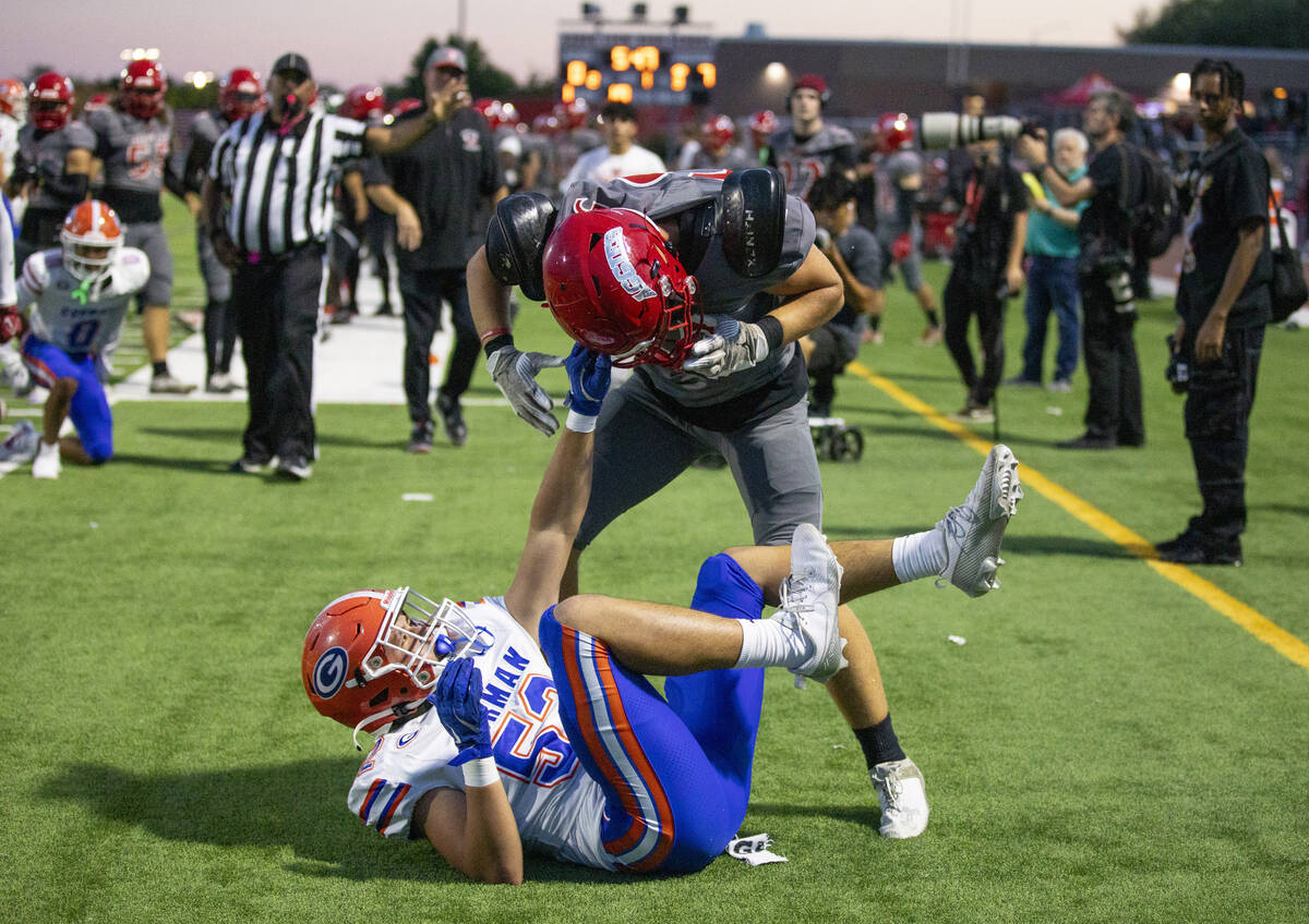 Bishop Gorman linebacker Brodey Correa (52) holds on to the helmet of Arbor View linebacker Roc ...