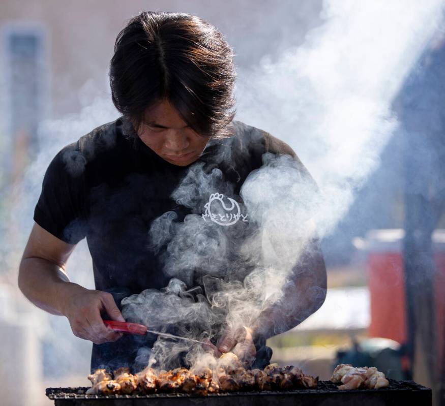 Takuto cooks chicken skewers at the Yakitori Yado food stand during the Aki Matsuri Japanese Fe ...