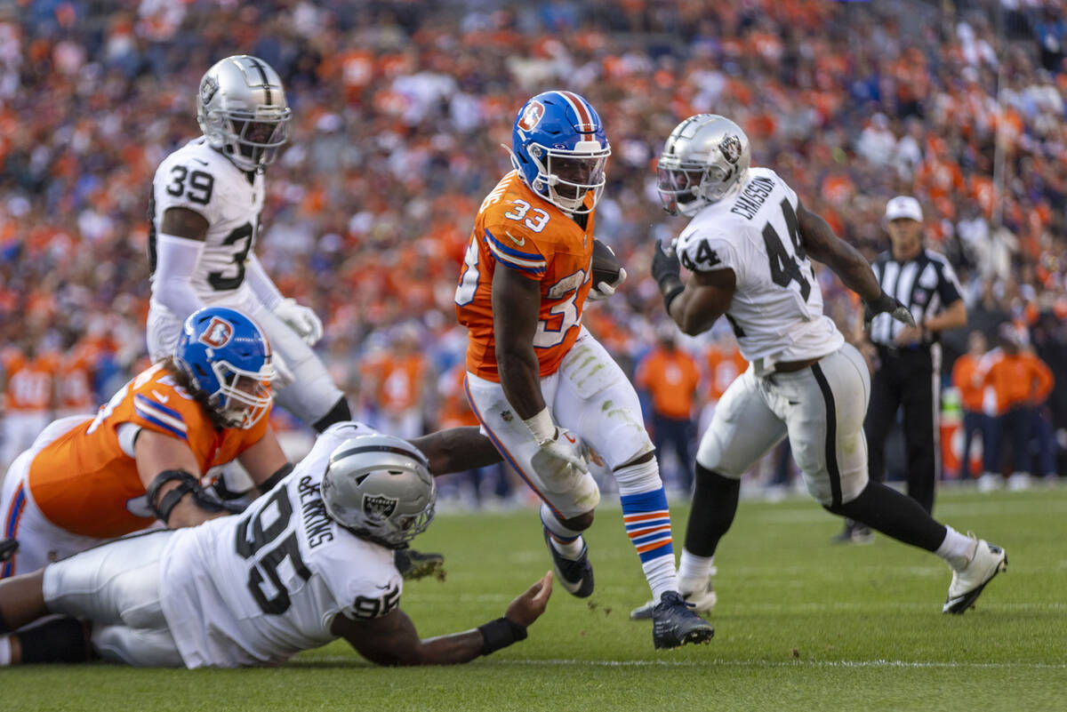 Denver Broncos running back Javonte Williams (33) rushes toward the end zone as Raiders defensi ...