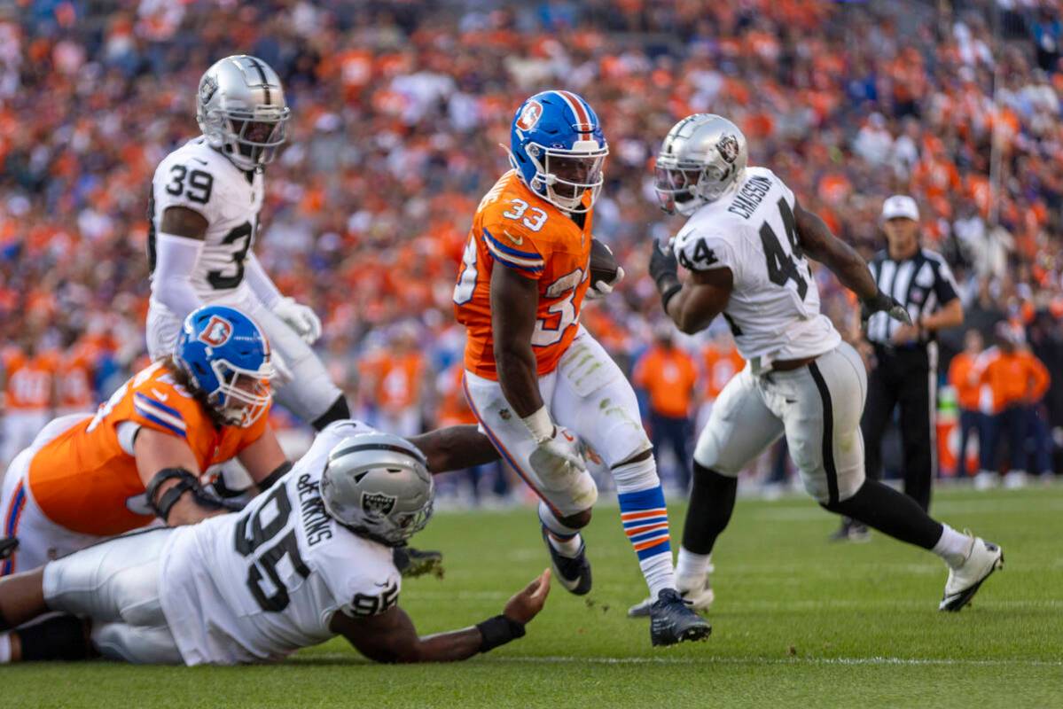 Denver Broncos running back Javonte Williams (33) rushes toward the end zone as Raiders defensi ...