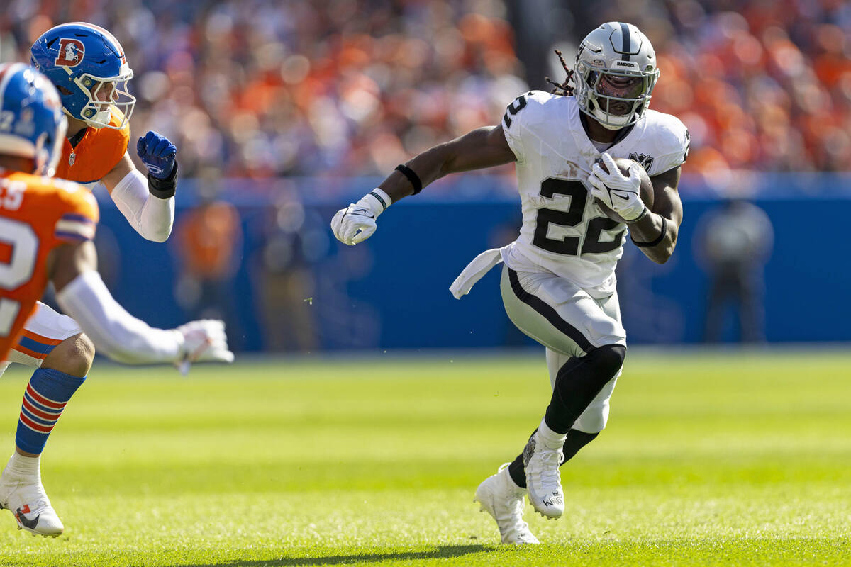 Raiders running back Alexander Mattison (22) looks for room to run as Denver Broncos safety Bra ...