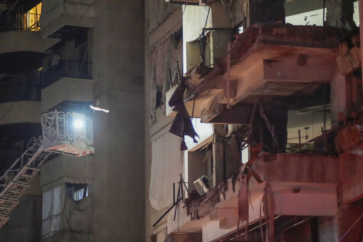 A rescue worker searches for survivors inside a damaged building hit by an Israeli airstrike in ...