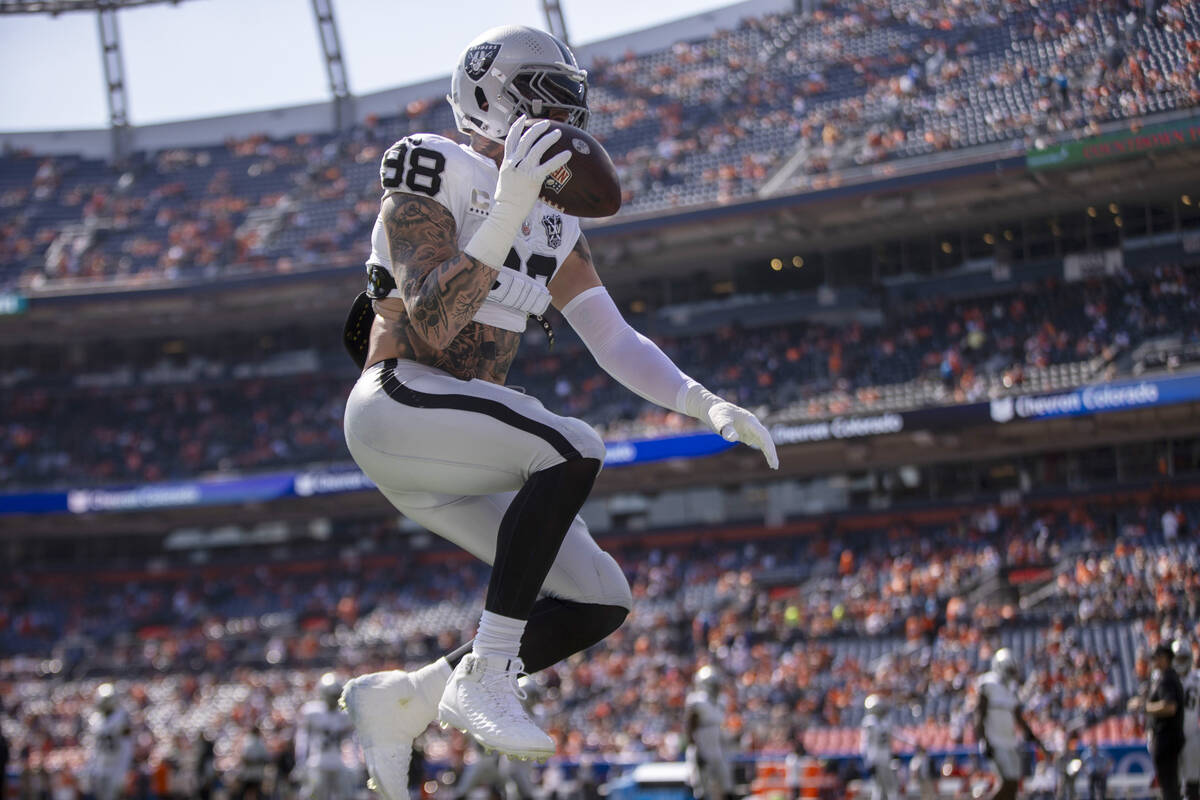 Raiders defensive end Maxx Crosby (98) leaps with a football during warm-ups before an NFL game ...