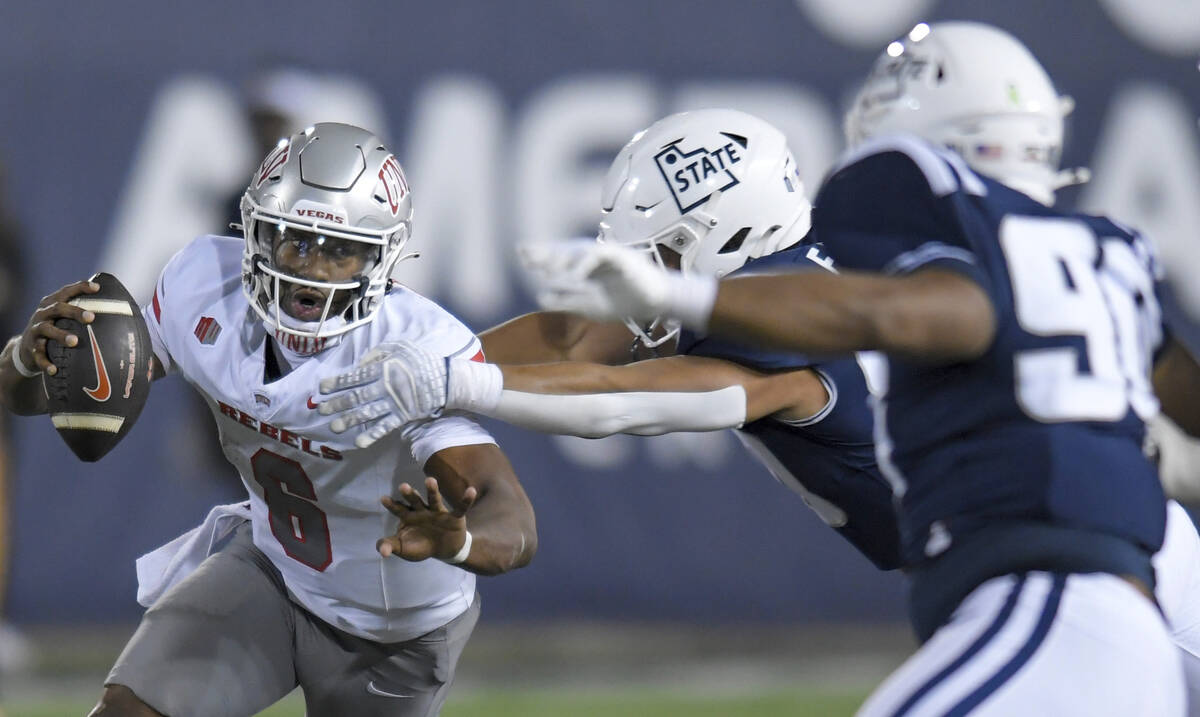 UNLV quarterback Hajj-Malik Williams (6) scrambles away from Utah State defensive end Lawrence ...