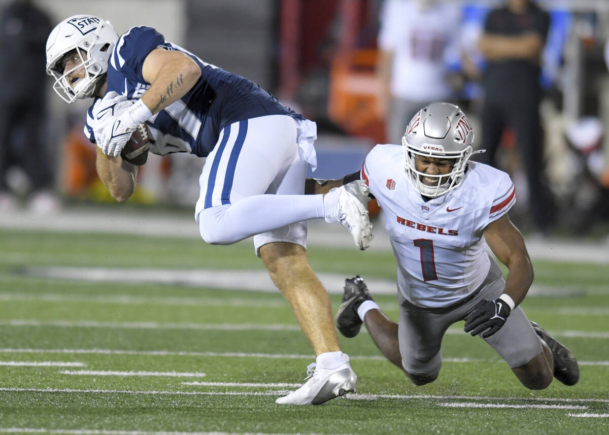 UNLV defensive back Jalen Catalon (1) tackles Utah State tight end Broc Lane, left, in the firs ...