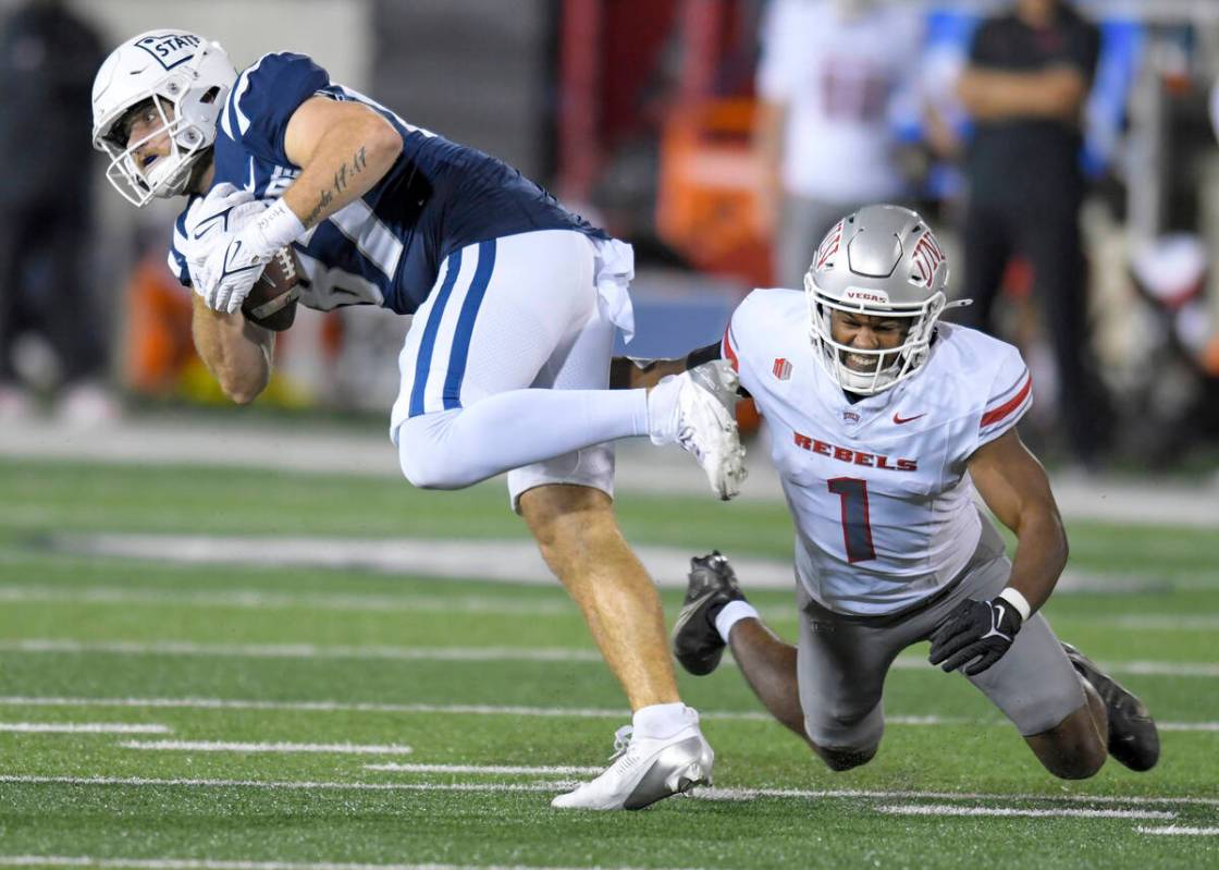 UNLV defensive back Jalen Catalon (1) tackles Utah State tight end Broc Lane, left, in the firs ...