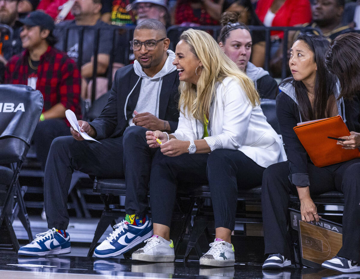 Aces head coach Becky Hammon laughs on the bench with assistant coach Tyler Marsh against ...