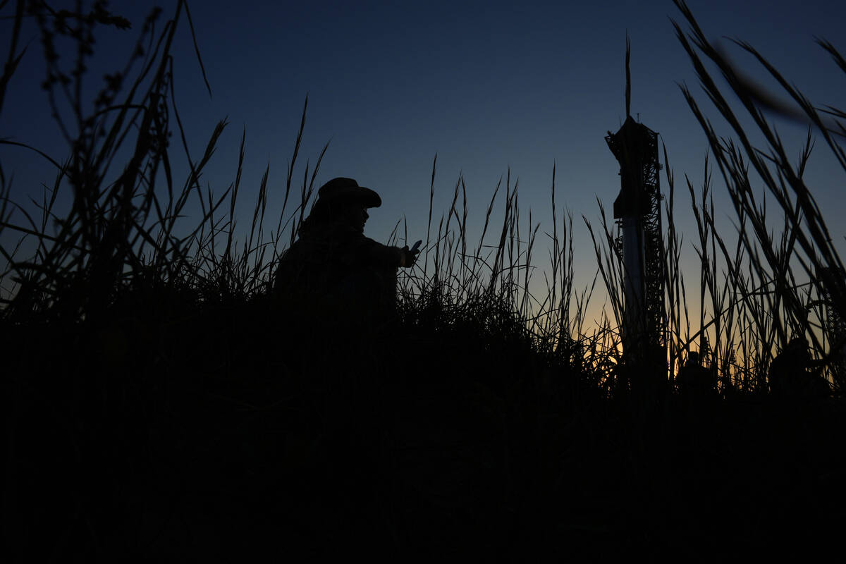 Noah Jansko watches as the sun sets behind SpaceX's mega rocket Starship, Saturday, Oct. 12, 20 ...