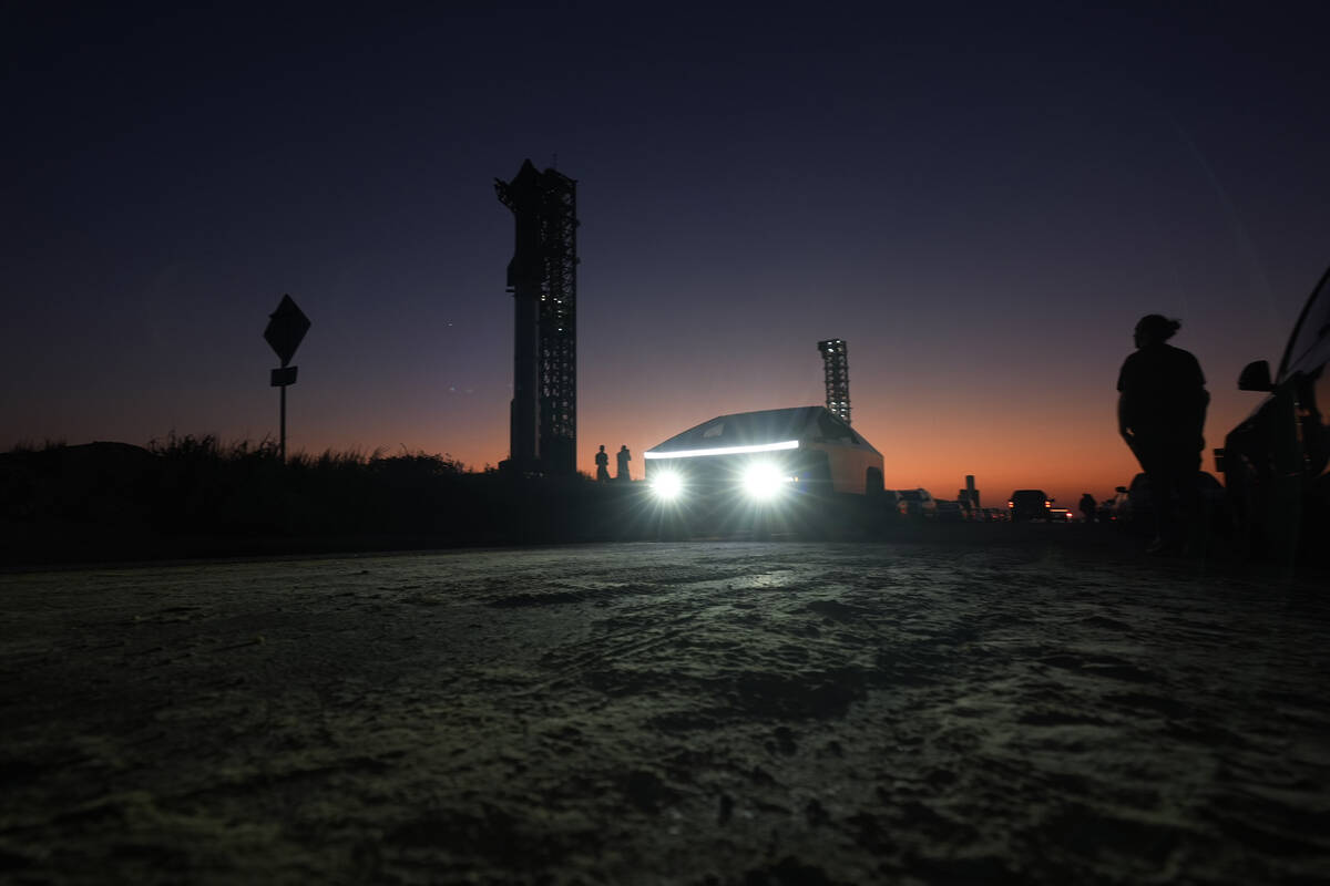 A Tesla Cybertruck passes as the sun sets behind SpaceX's mega rocket Starship, Saturday, Oct. ...