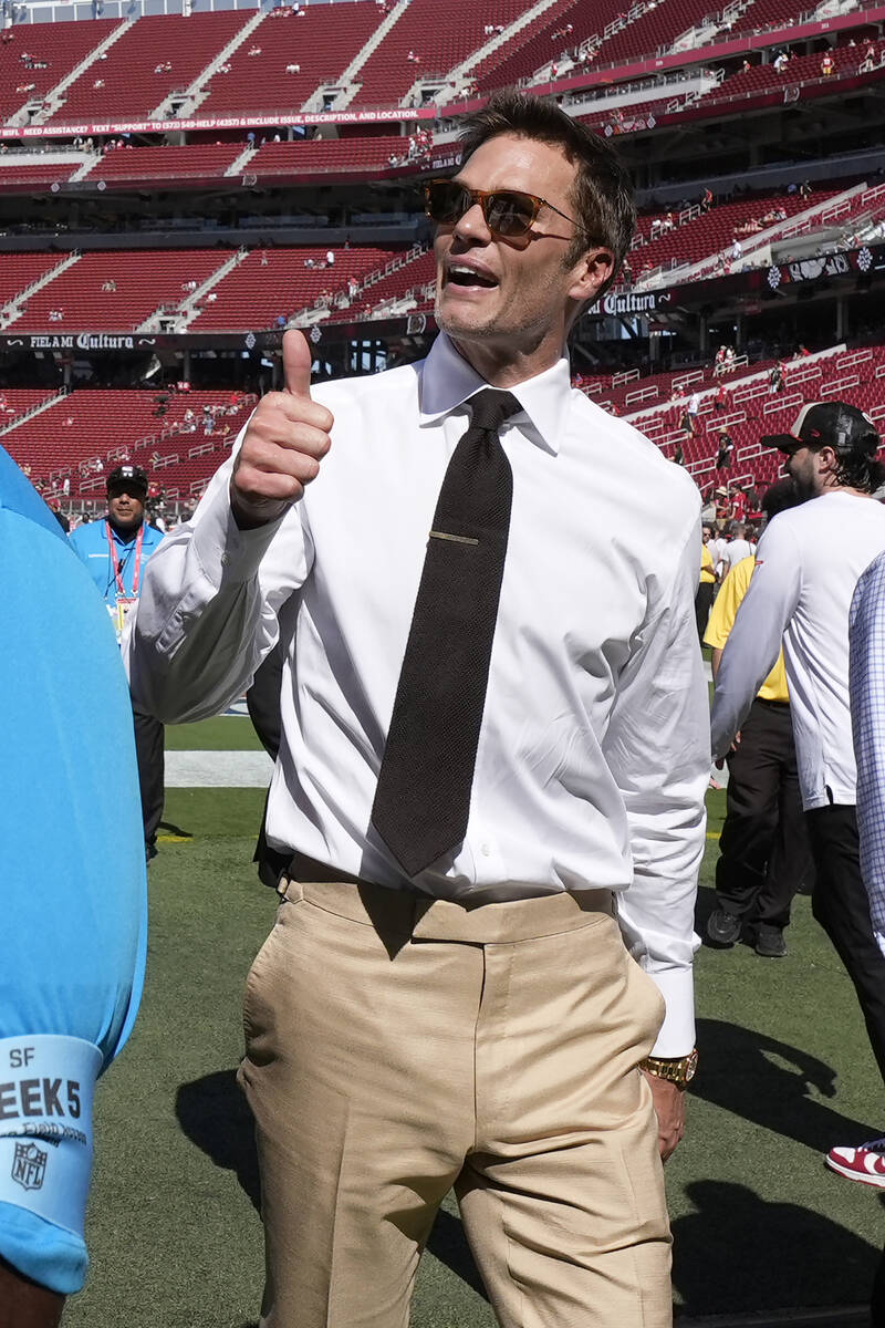 Former quarterback Tom Brady gestures to fans before an NFL football game between the San Franc ...