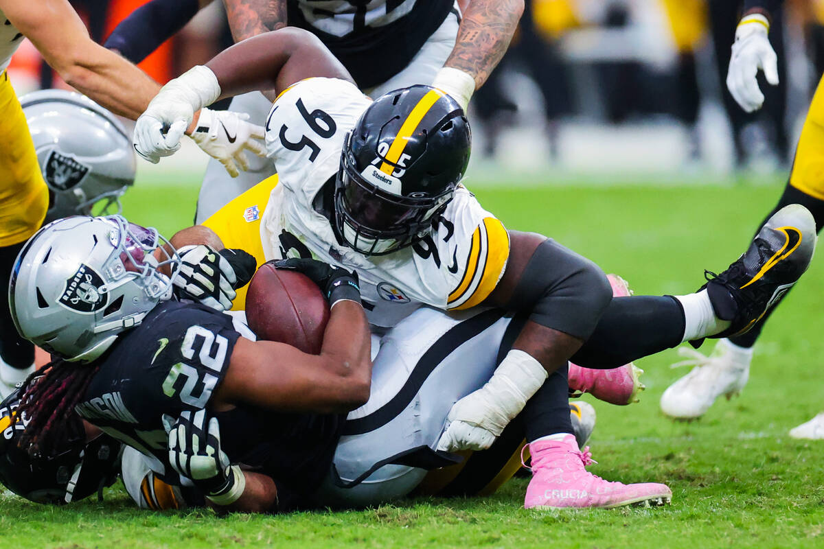 Raiders running back Alexander Mattison (22) is toppled by Pittsburgh Steelers defensive tackle ...