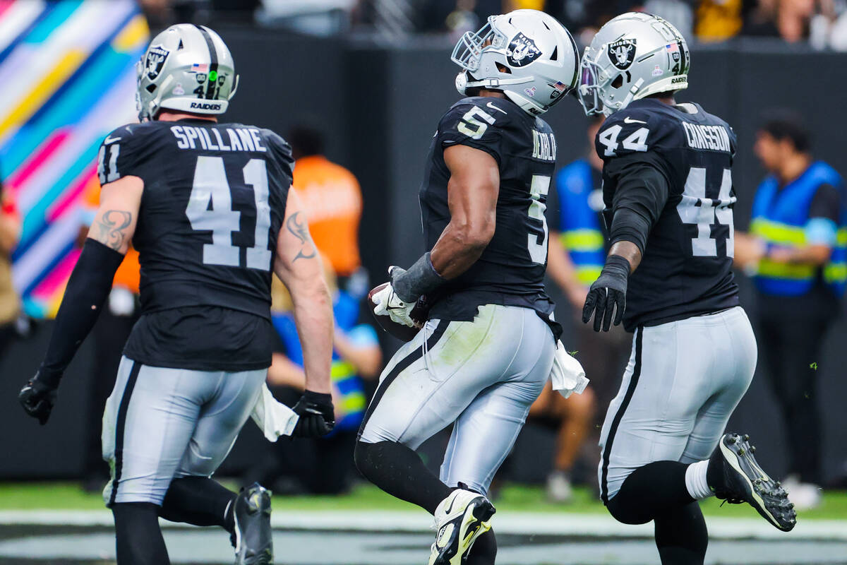 Raiders linebacker Robert Spillane (41) celebrates with linebacker Divine Deablo (5) and defens ...