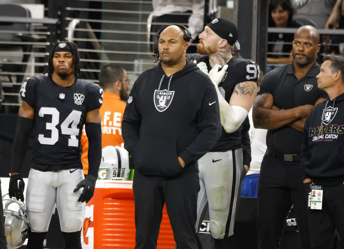 Raiders head coach Antonio Pierce and defensive end Maxx Crosby (98) safety Thomas Harper (34) ...