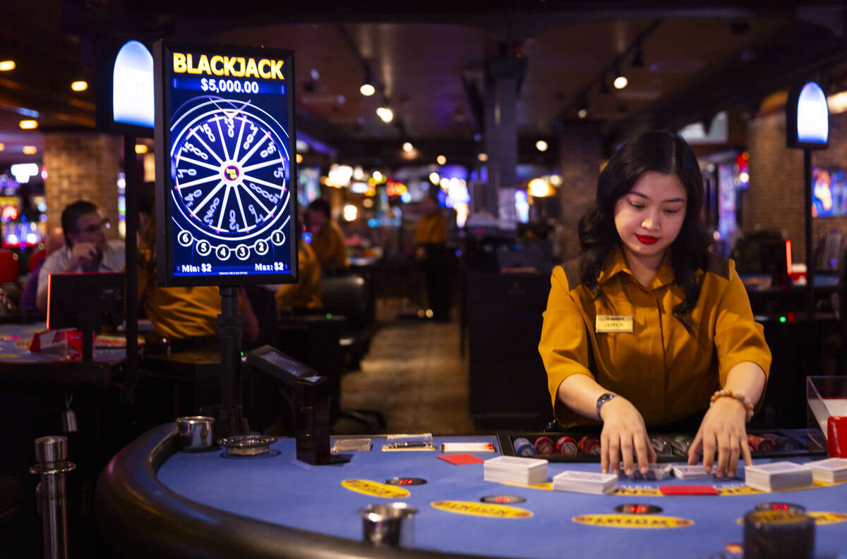 Dealer Joyce Ramos shuffles cards at a blackjack table at Binion’s on Thursday, Oct. 10, ...