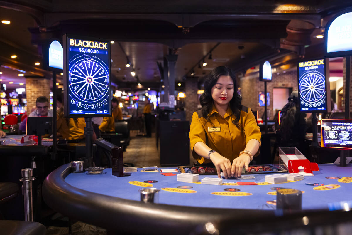 Dealer Joyce Ramos shuffles cards at a blackjack table at Binion’s on Thursday, Oct. 10, ...