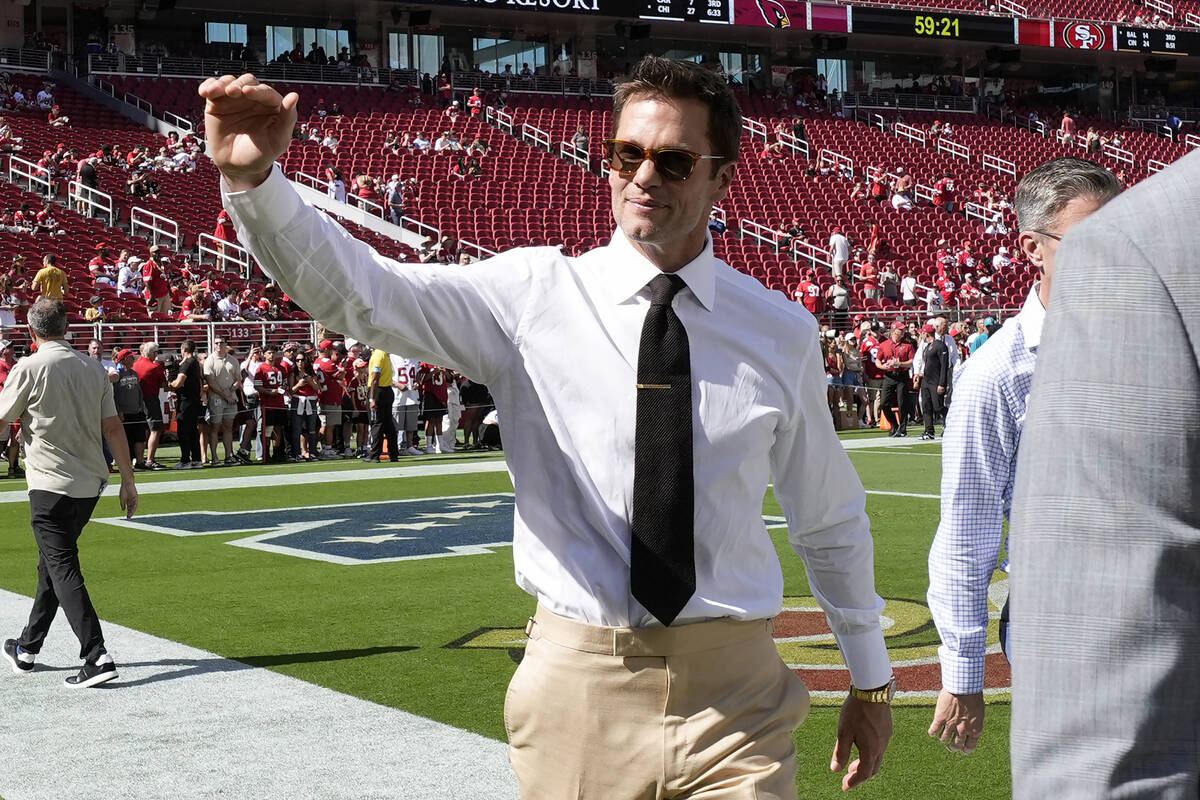 Former quarterback Tom Brady waves to fans before an NFL football game between the San Francisc ...