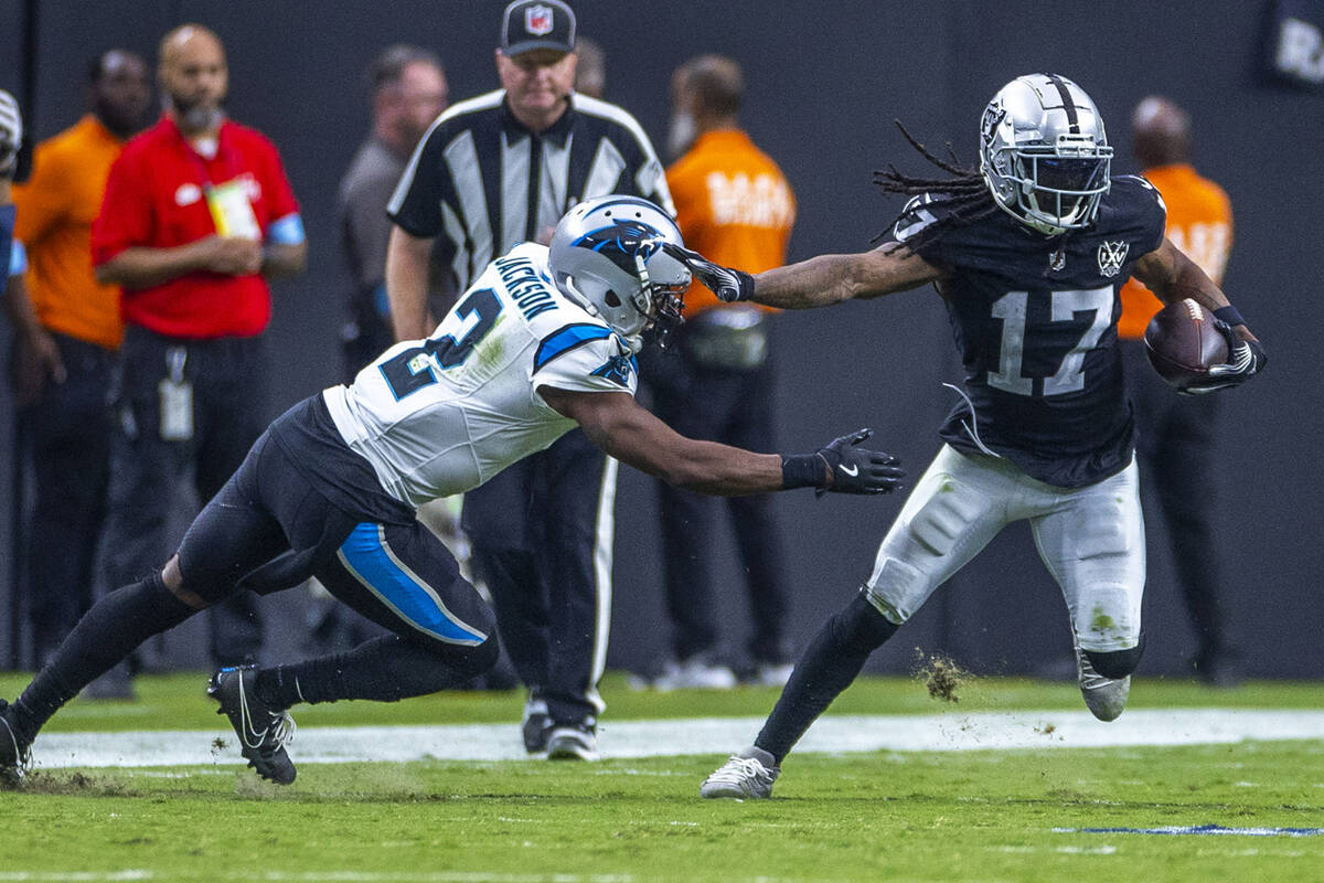 Raiders wide receiver Davante Adams (17) evades a tackle attempt by Carolina Panthers cornerbac ...