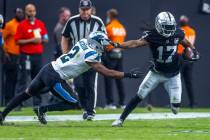 Raiders wide receiver Davante Adams (17) evades a tackle attempt by Carolina Panthers cornerbac ...