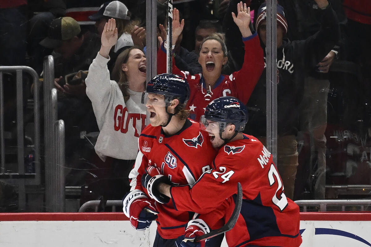 Washington Capitals defenseman Jakob Chychrun, left, is embraces by Washington Capitals center ...