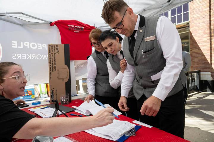 Sheraton Grand Hotel workers Lupe Ventura, center, and Alex Ivanitsky, right, who are represent ...