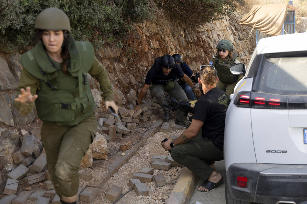 Israeli soldiers run for a cover as siren warning for rockets and missiles heard during a media ...