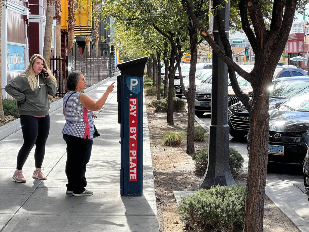 Marta Buchanan of Tucson, Ariz., pays for parking at a payment machine on 7th Street in downtow ...