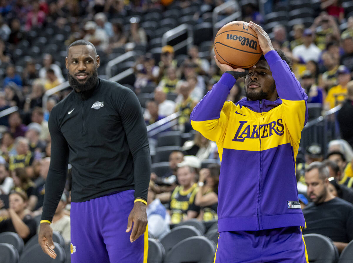 Los Angeles Lakers forward LeBron James, left, watches guard Bronny James Jr., right, shoot the ...