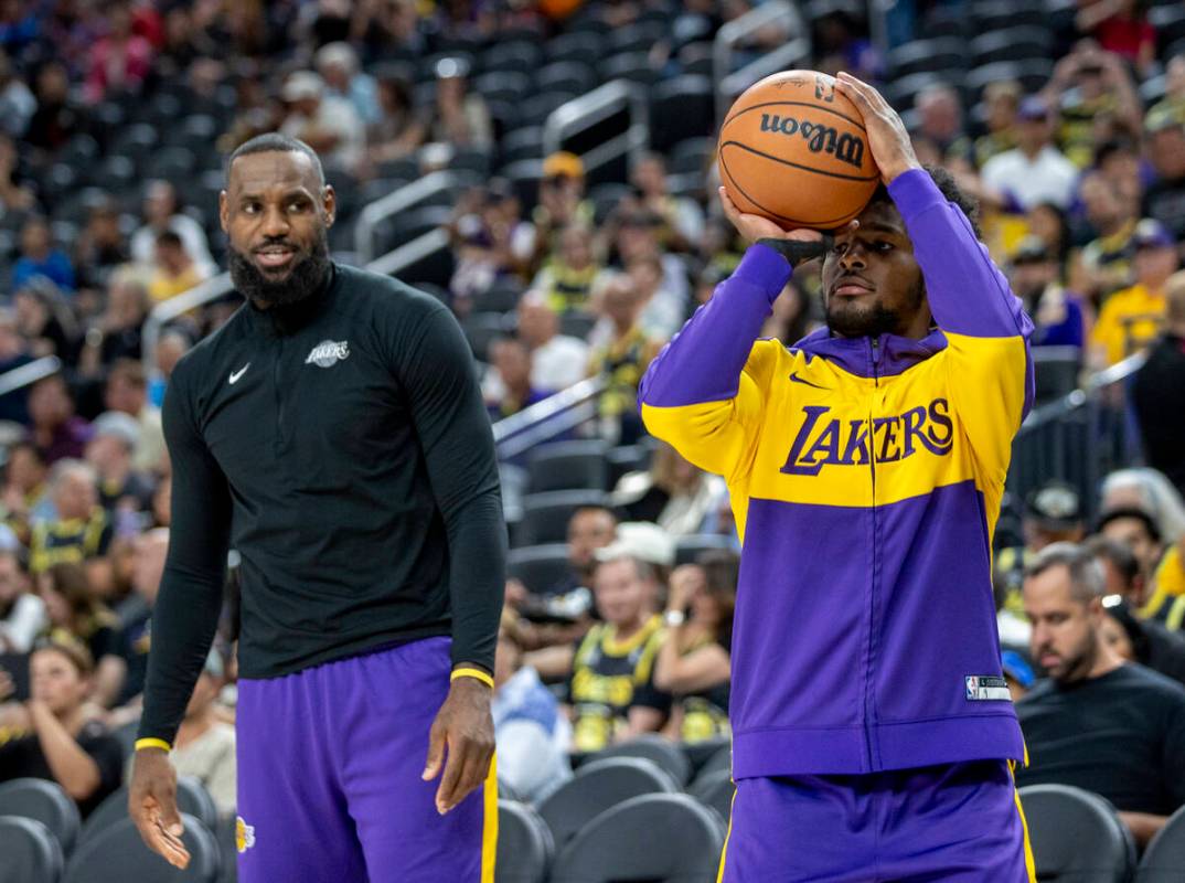 Los Angeles Lakers forward LeBron James, left, watches guard Bronny James Jr., right, shoot the ...