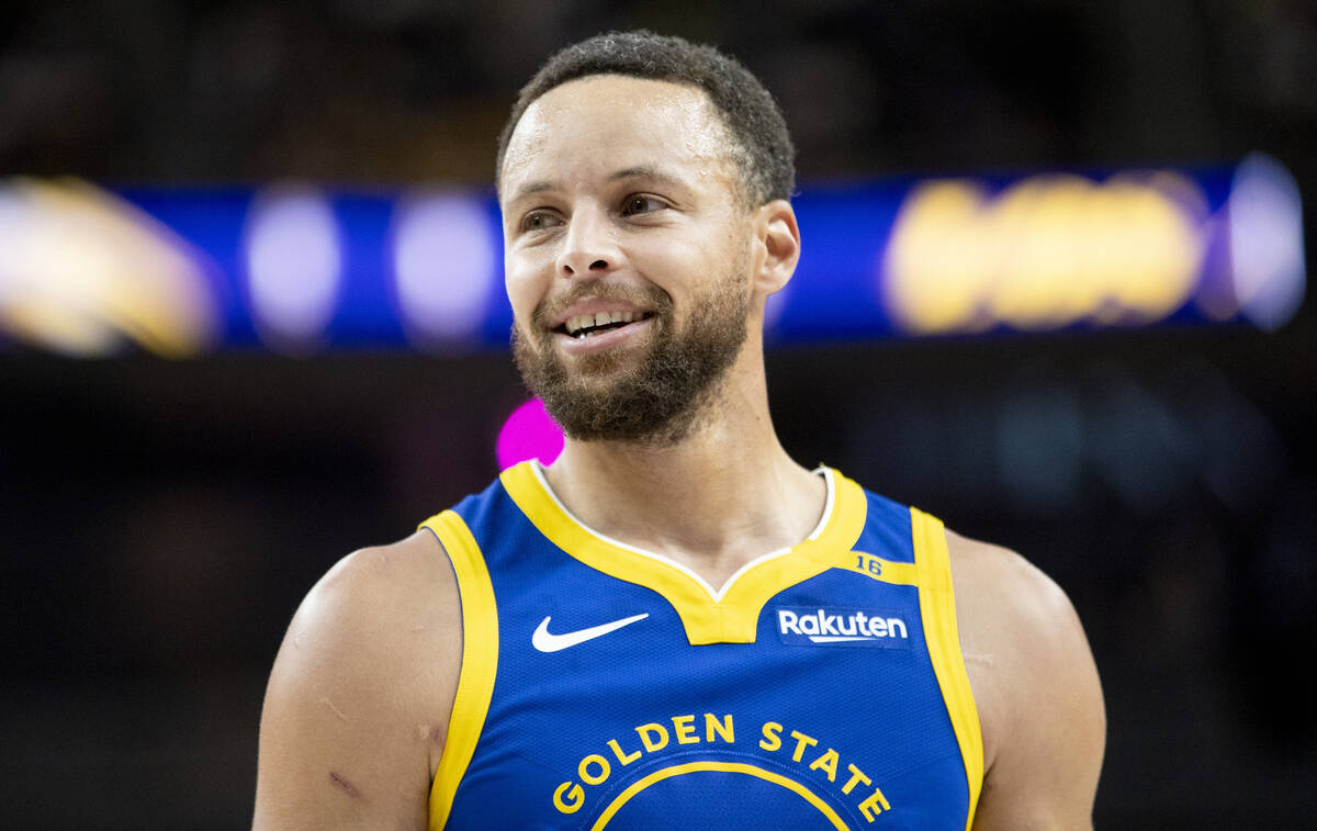 Golden State Warriors guard Stephen Curry smiles during the NBA preseason basketball game again ...