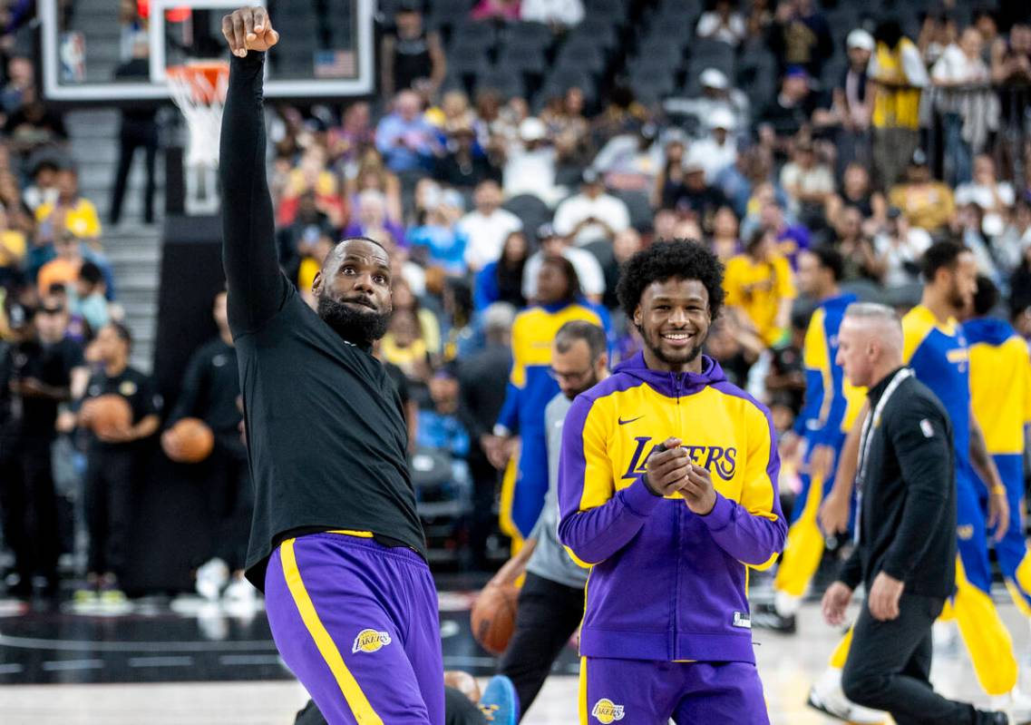 Los Angeles Lakers forward LeBron James, left, and guard Bronny James Jr., right, warm up befor ...