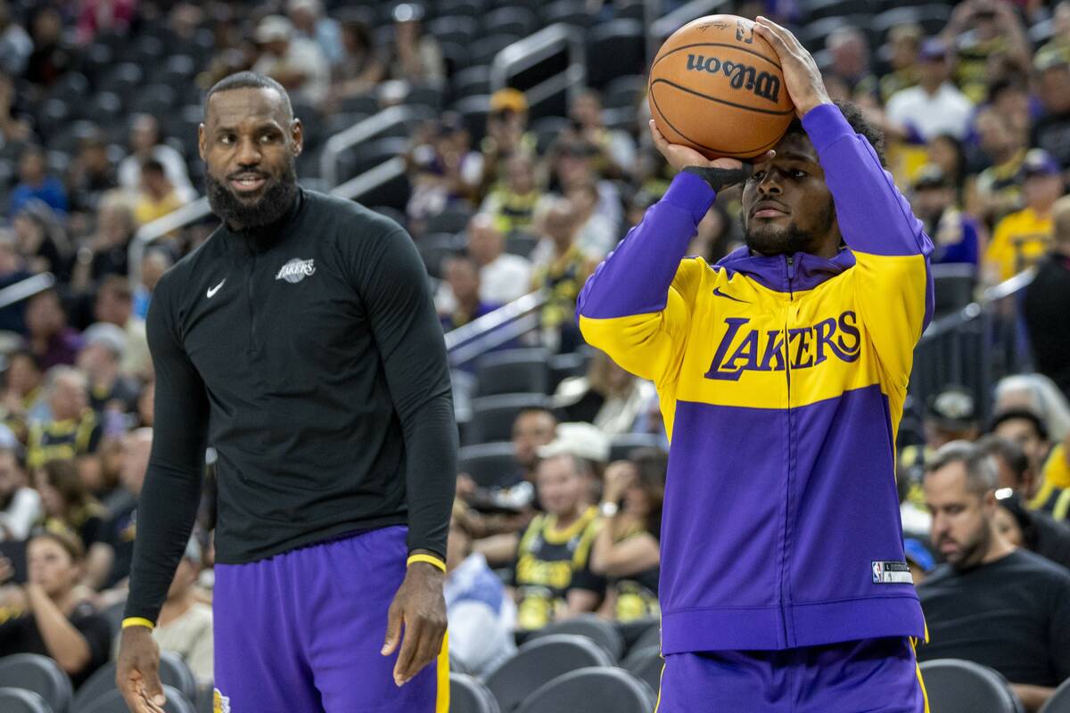 Los Angeles Lakers forward LeBron James, left, watches guard Bronny James Jr., right, shoot the ...