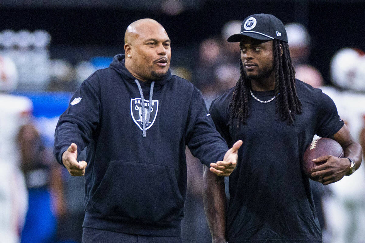 Raiders Head Coach Antonio Pierce chats with wide receiver Davante Adams (17) during the warm u ...