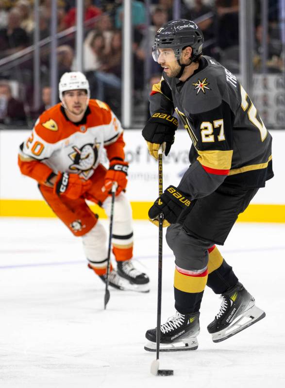 Golden Knights defenseman Shea Theodore (27) controls the puck during the NHL hockey game again ...