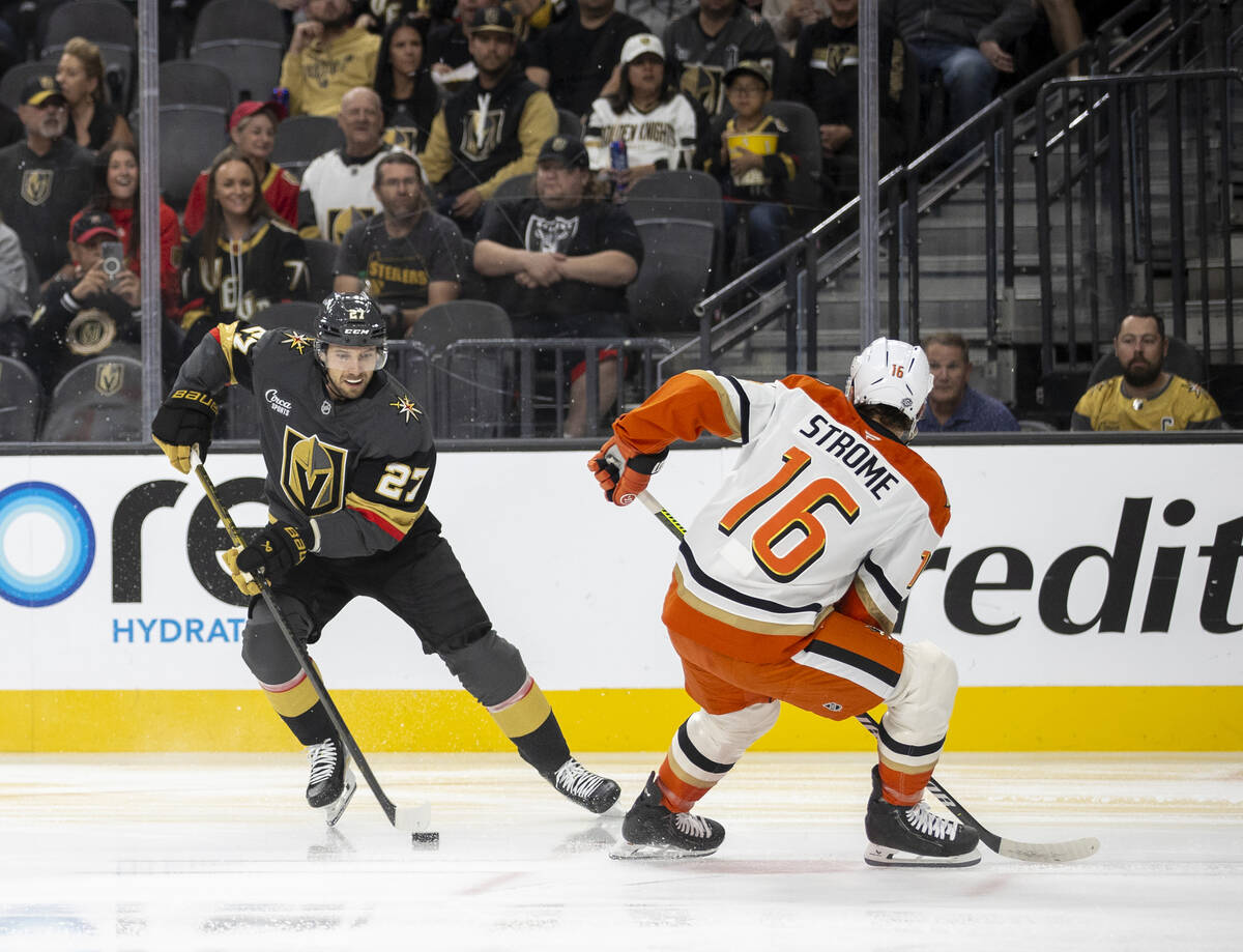 Golden Knights defenseman Shea Theodore (27) keeps the puck from Anaheim Ducks center Ryan Stro ...