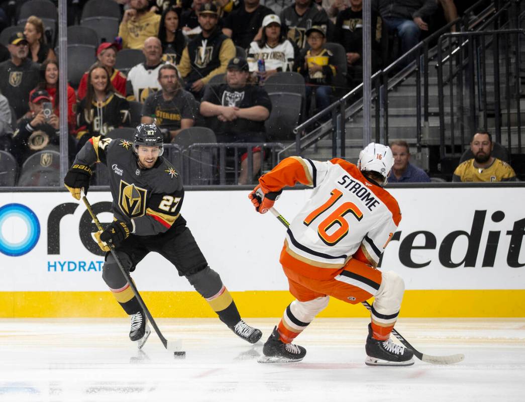 Golden Knights defenseman Shea Theodore (27) keeps the puck from Anaheim Ducks center Ryan Stro ...