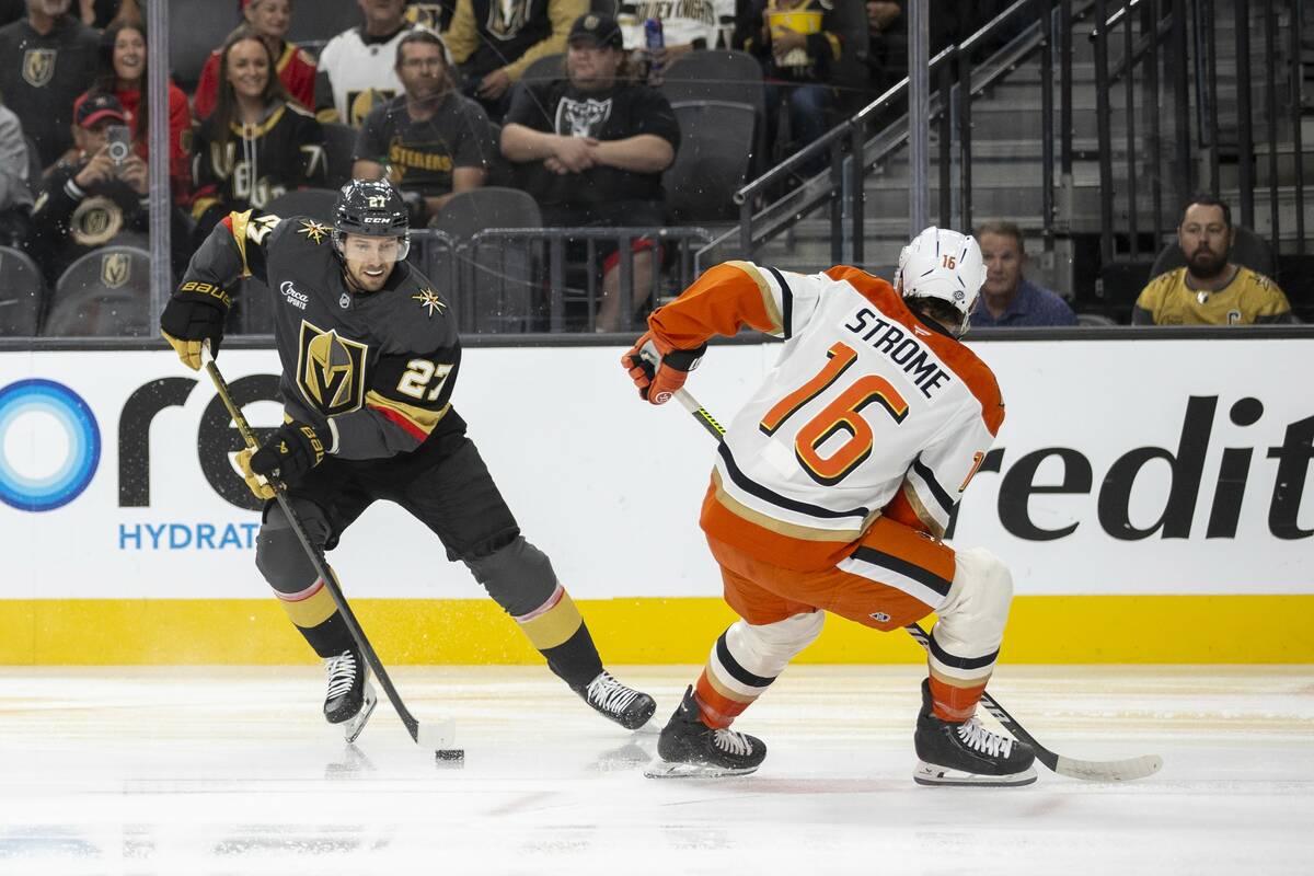 Golden Knights defenseman Shea Theodore (27) keeps the puck from Anaheim Ducks center Ryan Stro ...