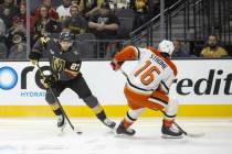 Golden Knights defenseman Shea Theodore (27) keeps the puck from Anaheim Ducks center Ryan Stro ...