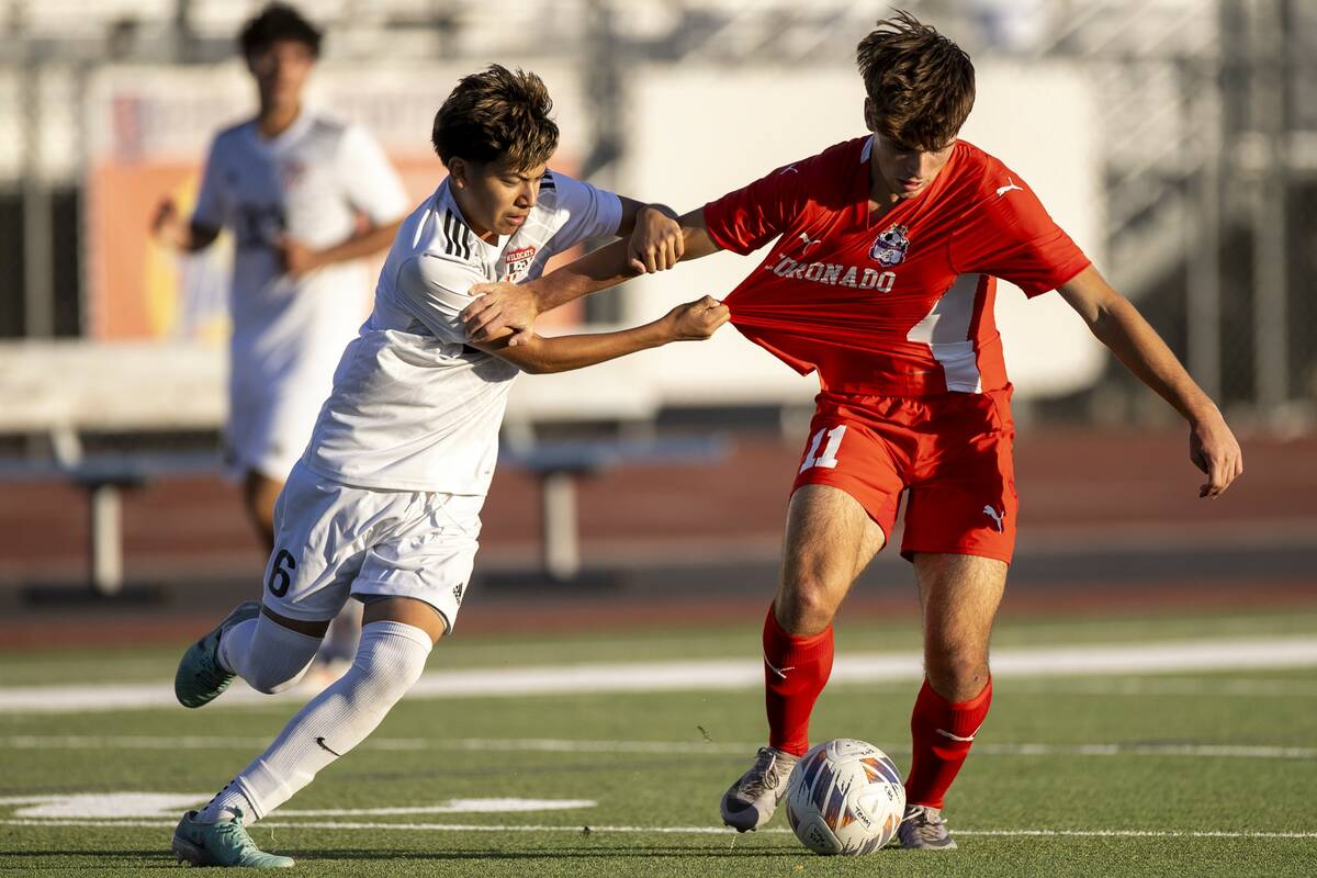 Coronado junior Gavin Flickinger (11) and Las Vegas High midfielder Israel Pelaez Jr. (6) compe ...