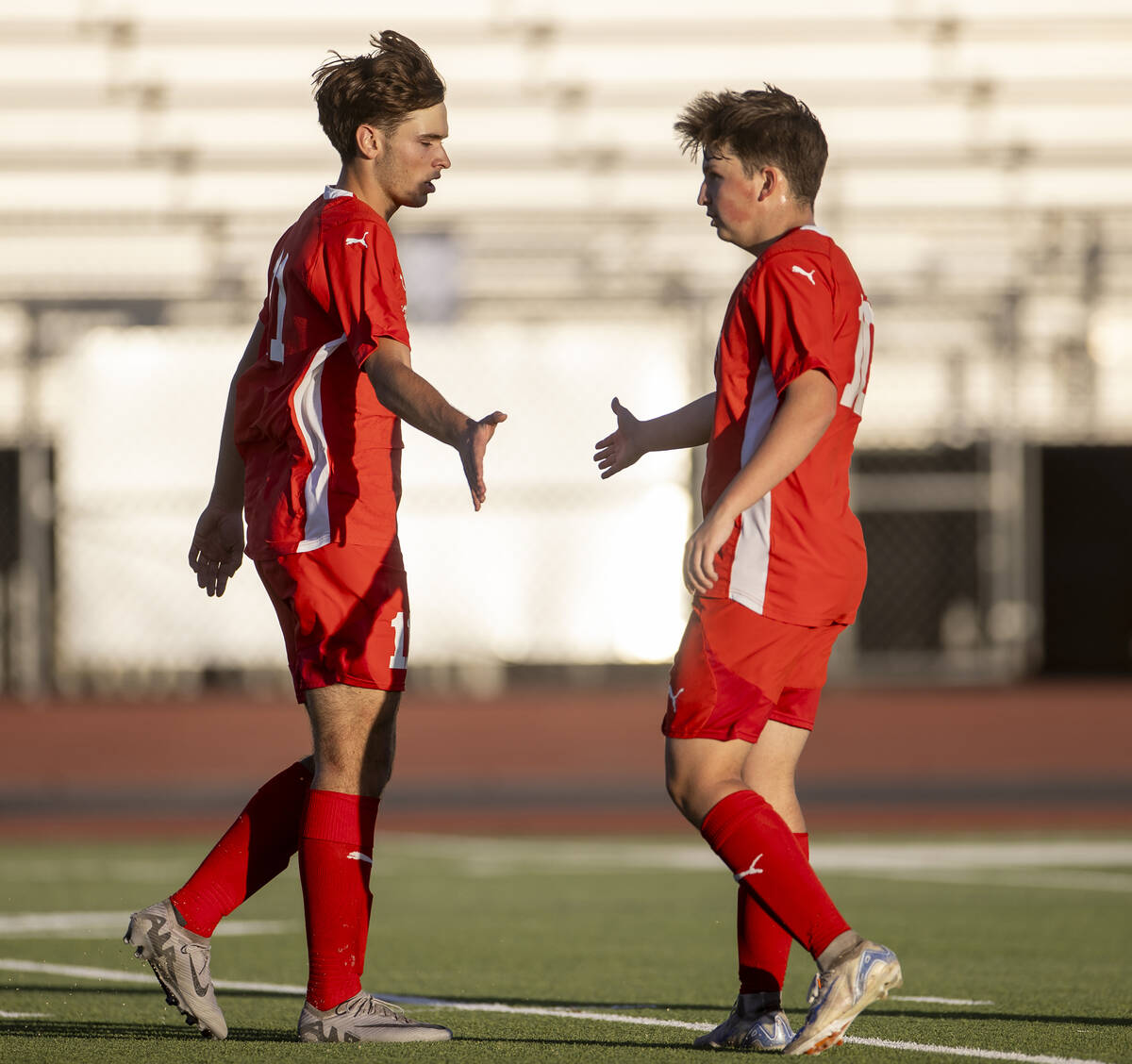 Coronado junior Gavin Flickinger, left, high-fives Coronado midfielder Aiden Sena, right, after ...