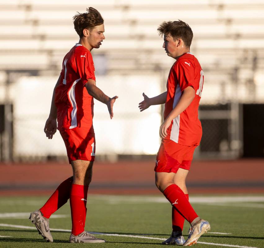 Coronado junior Gavin Flickinger, left, high-fives Coronado midfielder Aiden Sena, right, after ...